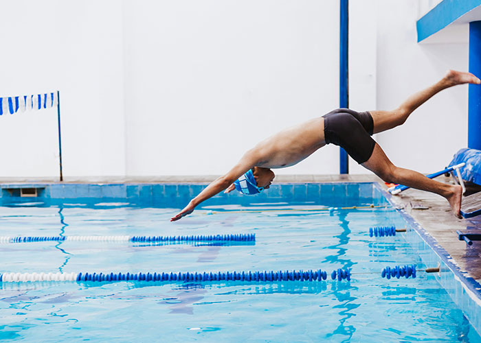 Joven nadador realizando clavado en piscina deportiva relacionado con hallazgos sorprendentes en autopsias.