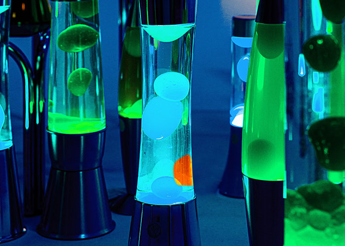 Glowing lava lamps in dark room representing medical examinations uncovering disturbing truths about death.