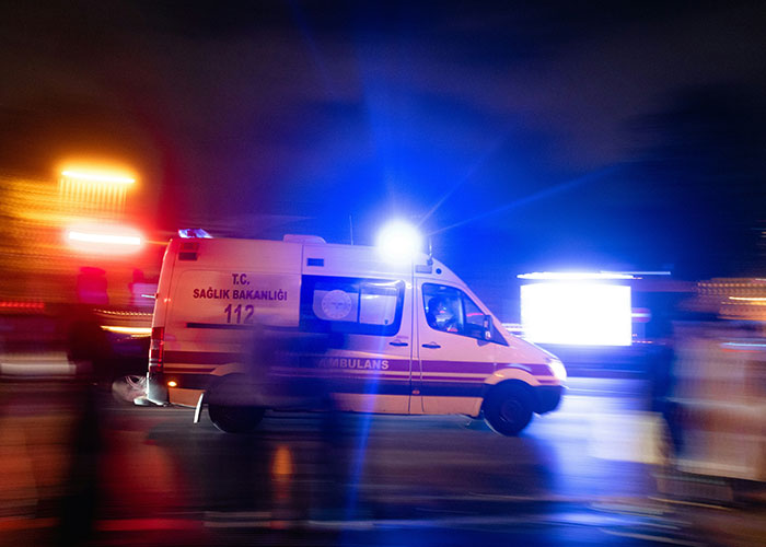 Ambulance with flashing lights at night, symbolizing urgent medical examinations uncovering truths about death.