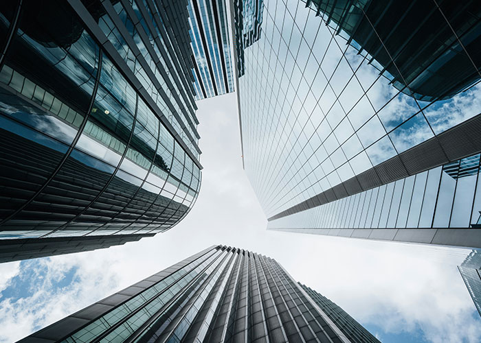 Edificios altos de vidrio reflejando el cielo, representando temas relacionados con hallazgos sorprendentes en autopsias.