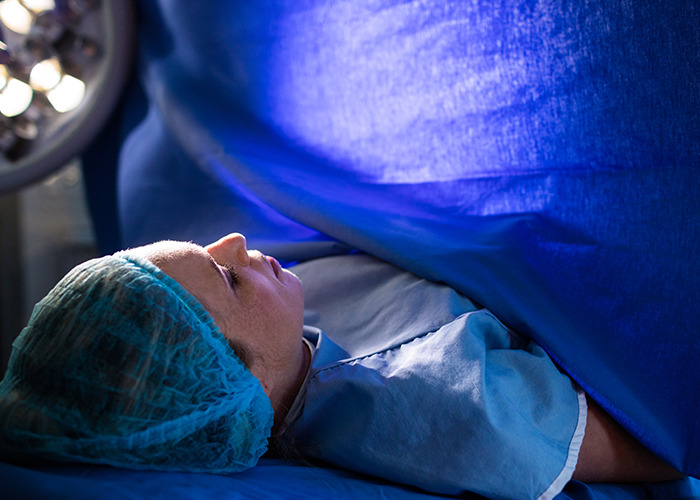 Mother in maternity ward preparing for childbirth with medical staff, highlighting dad in maternity wards presence and support.