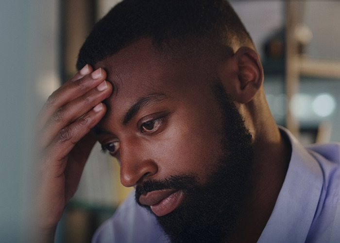 Stressed man with hand on forehead, symbolizing wild and infuriating dad in maternity wards stories experience.