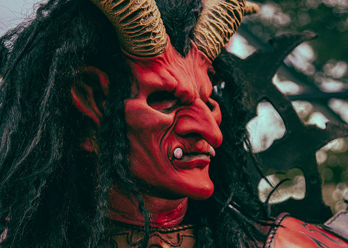 Man in elaborate horned costume and face paint portraying a wild character related to dad in maternity wards stories.