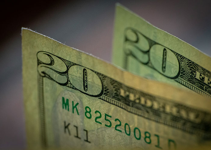 Close-up of twenty dollar bills illustrating instant karma manifestations with money in focus.