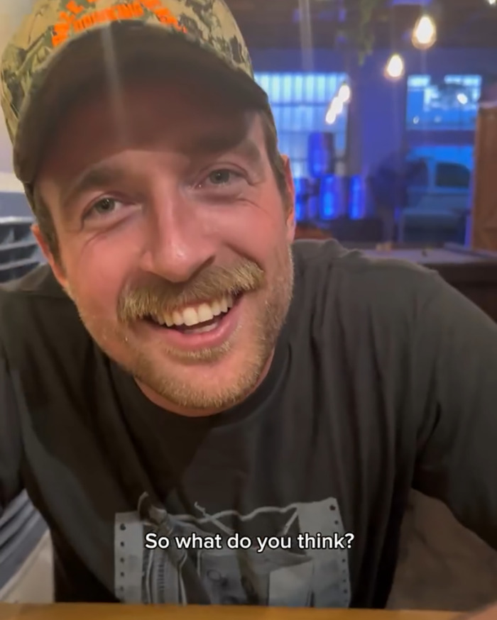 Man with a cap smiling indoors with text caption asking for opinion about psychic drawing and love life changes.