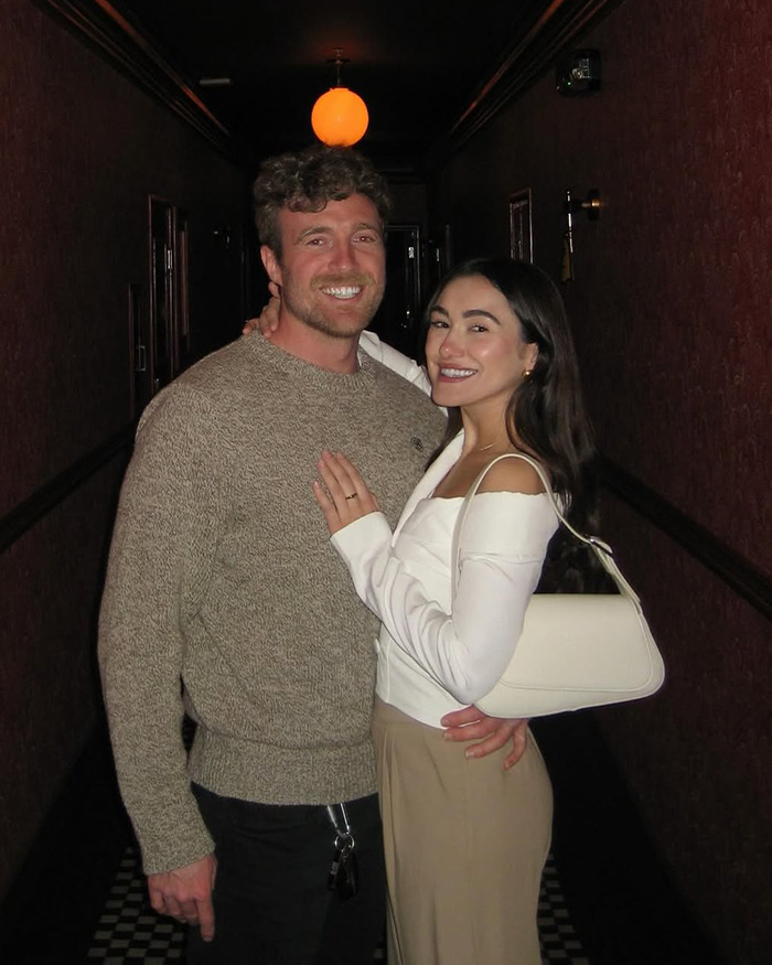 Couple smiling and embracing in dim hallway, celebrating love life changes after psychic drawing went viral.