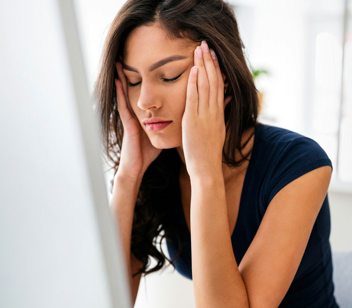 Woman upset and stressed after bride-to-be asks her to pay for her own bridesmaid dress, showing shock and frustration.