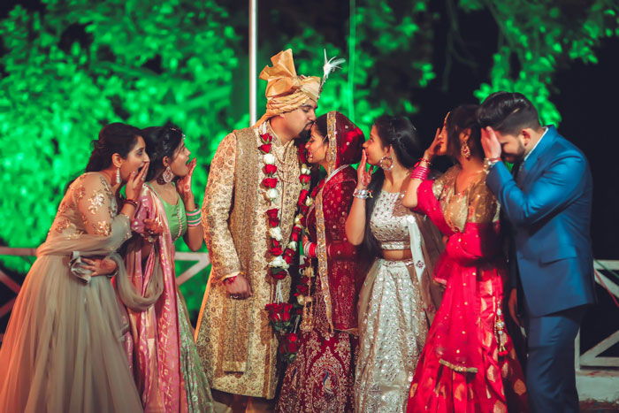 Bride and bridesmaids in traditional attire at an outdoor wedding, highlighting upset woman over bridesmaid dress payment.