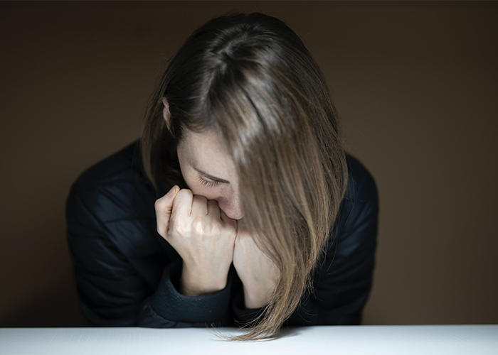 Woman upset and hiding face, reflecting emotions after confrontation over inappropriate Halloween costume.