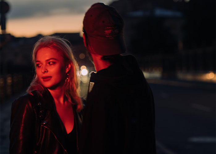 Woman confronts boyfriend&rsquo;s female friend at night, tense moment related to inappropriate Halloween costume conflict.