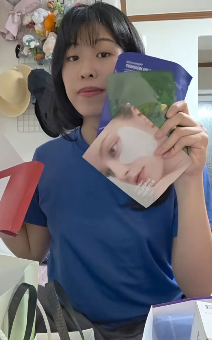 Woman holding skincare gifts received while interviewing for jobs in Korea, showing excitement and product variety indoors.