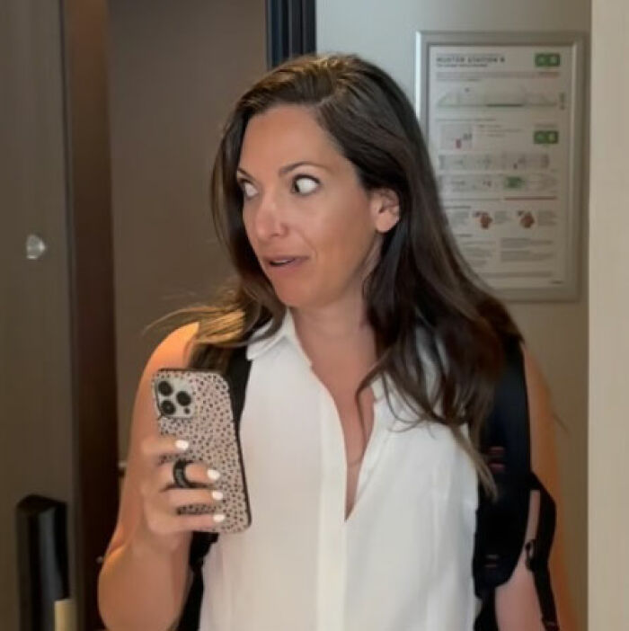 Woman holding phone with surprised expression after using Meta glasses to record vacation footage and regrets her mistake