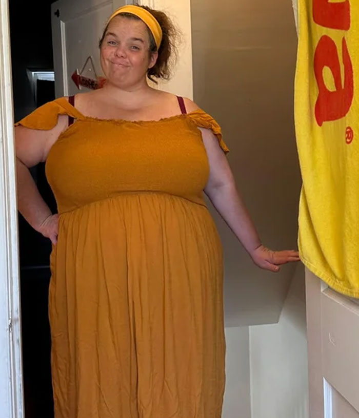 Woman wearing a yellow dress and headband standing in doorway, sharing how Costco helped with weight loss journey.