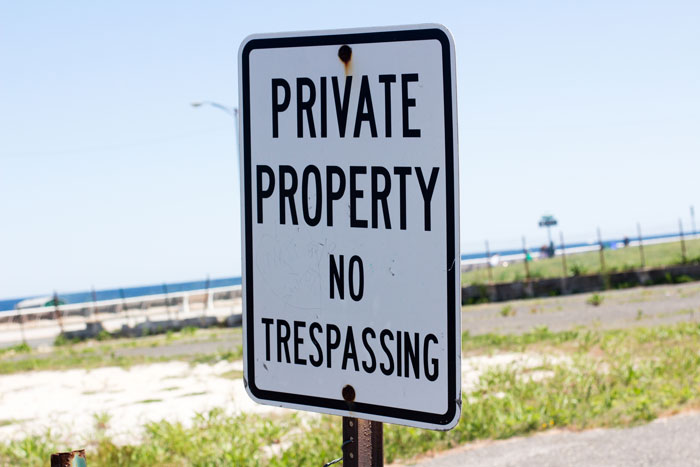 Private property sign near yard and pool area signaling no trespassing, highlighting new homeowners fencing land.