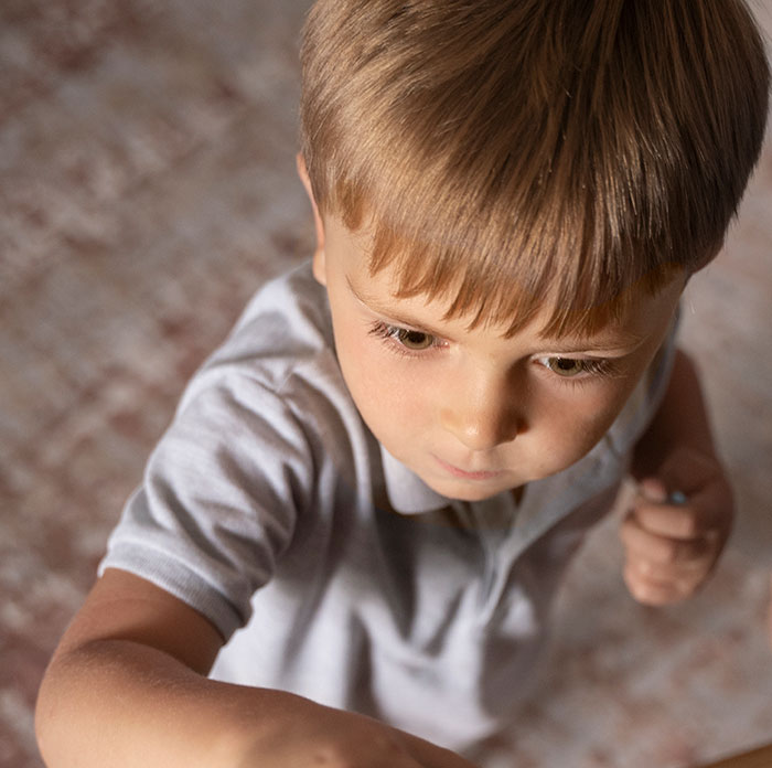Young boy reaching forward indoors, illustrating babysitting moments and awkward experiences from babysitters' stories.