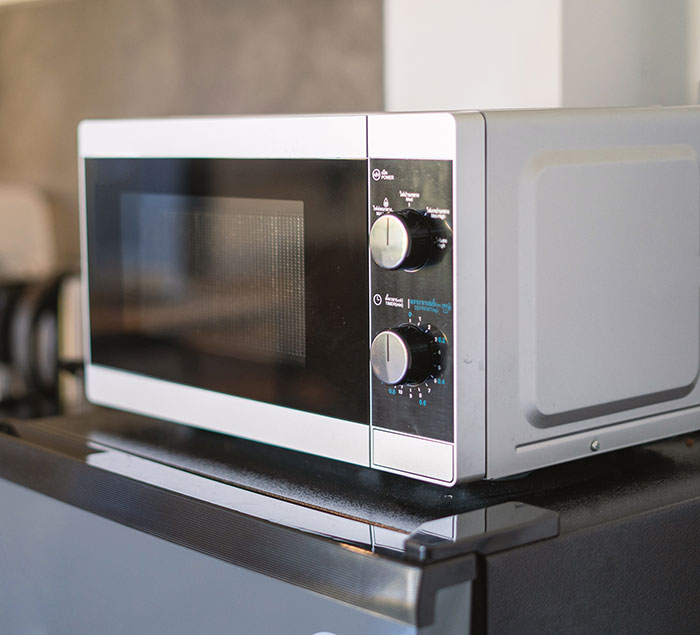 White microwave on countertop, representing babysitters' weird and awkward moments while on the job at home.