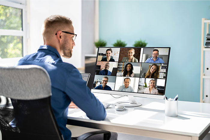 Man attending a virtual meeting on computer, illustrating common examples of people failed spectacularly at work.