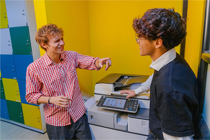 Two coworkers struggling with a copier in an office, illustrating times people failed spectacularly at work.