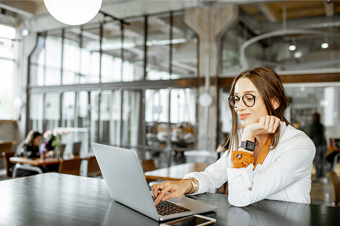 Young woman working on laptop in an office, illustrating common times people failed spectacularly at work moments.
