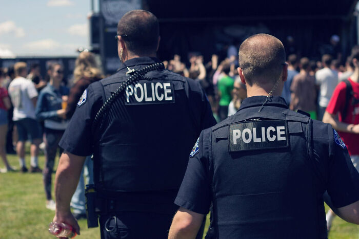 Two police officers monitoring a crowded outdoor event, related to worst Halloween experiences turning fun into nightmares.