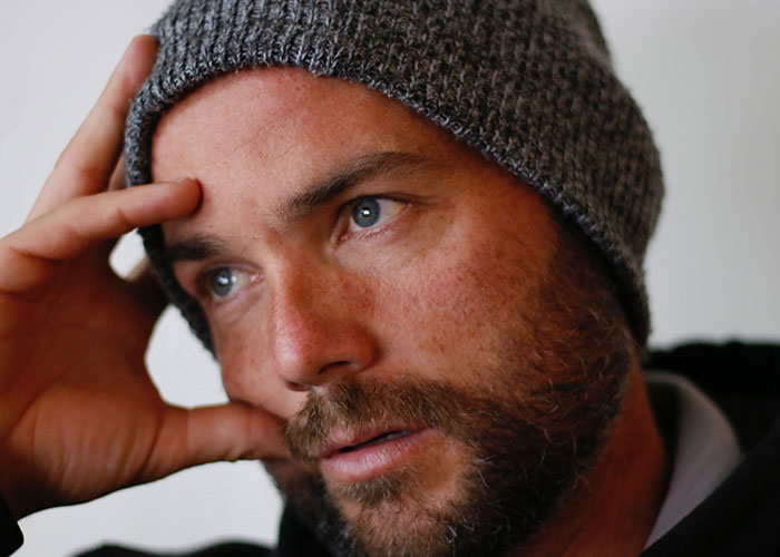 Close-up of a man wearing a knitted hat, reflecting thoughtfully while sharing myths about men that are simply not true.