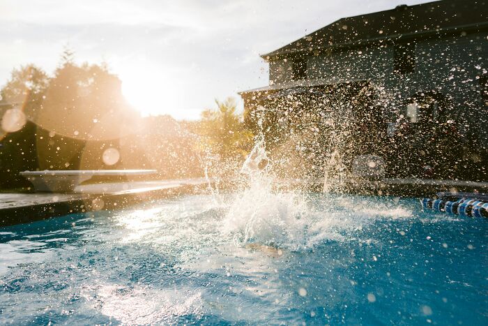 Children splashing and playing in a backyard pool during a chaotic and unforgettable disastrous playdate in the late afternoon sun.