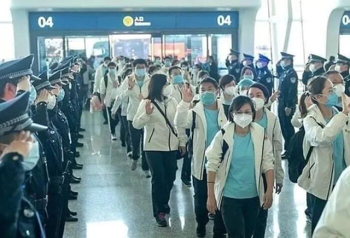 Grupo de profesionales médicos con mascarillas caminando en aeropuerto, destacados en publicaciones médicas extrañas y perturbadoras online.