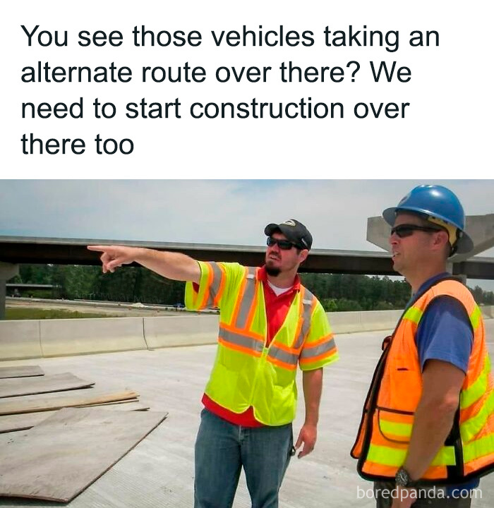 Two construction workers in safety vests and helmets discussing roadwork and alternate vehicle routes in a highway setting.