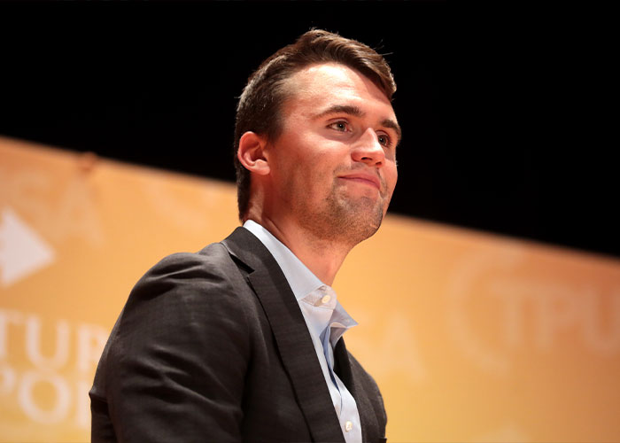 Young man in a dark blazer looking attentive during a public speaking event about acting and gestures.