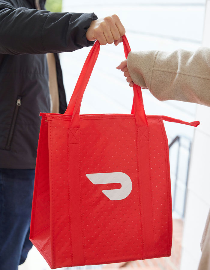 DoorDash driver handing over a red delivery bag while being involved in arrest after recording customer video incident. DoorDash driver handing over a red delivery bag while being involved in arrest after recording customer video incident.