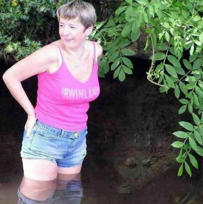 Woman standing in water with an alligator behind her captured in a frozen frame showing the unexpected aftermath.