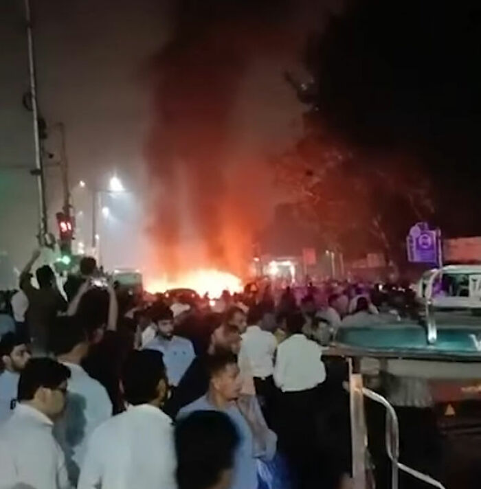 Crowd gathers near a large car blast fire at night as horror car blast shakes the capital city with chaos and emergency response.