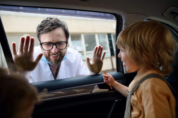Man prioritizes work, pretending not to have a family, while interacting with child through car window. Man prioritizes work, pretending not to have a family, while interacting with child through car window.