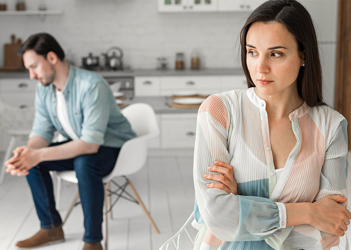 Couple in a tense kitchen scene, with man treating wife like his servant and woman looking upset and distant.