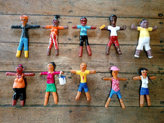 Colorful handmade clay figures arranged on wooden surface illustrating woman&rsquo;s unexpected savage revenge on petty neighbor concept.