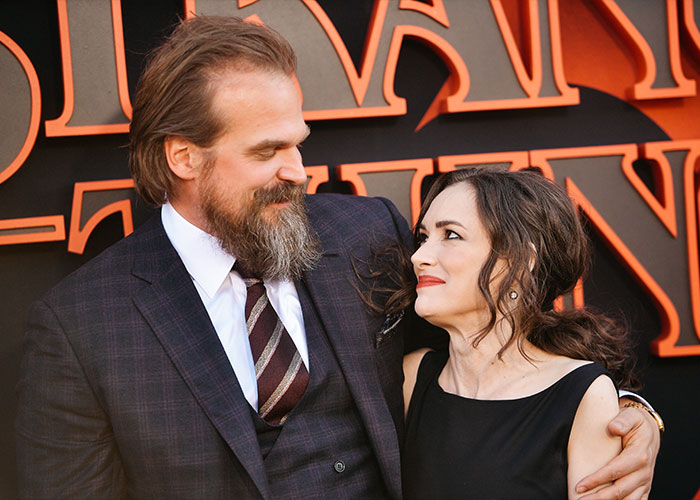 David Harbour and Stranger Things co-star sharing a warm moment at a red carpet event promoting the show.