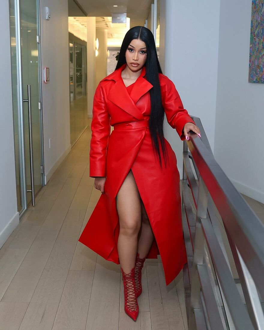 Cardi B in bold red coat and heels posing indoors, illustrating unexpected stars on members-only fan pages.