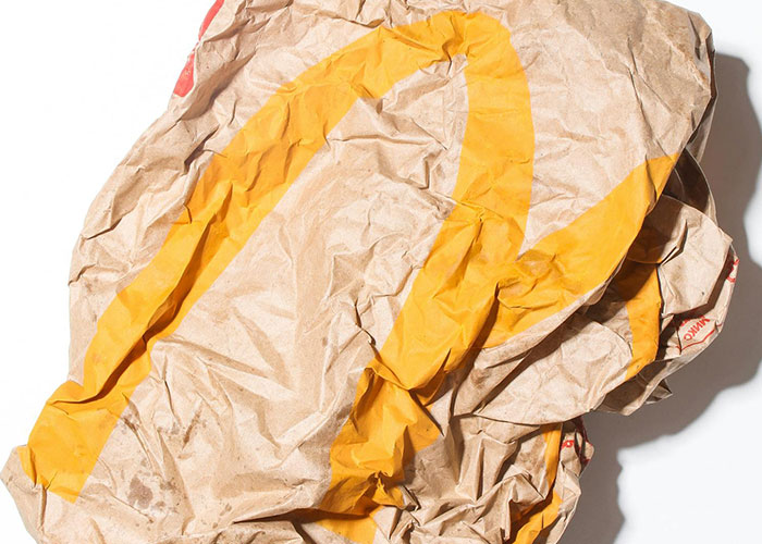 Crumpled vintage paper bag with yellow print, an unusual item found in the walls of homes during renovations.