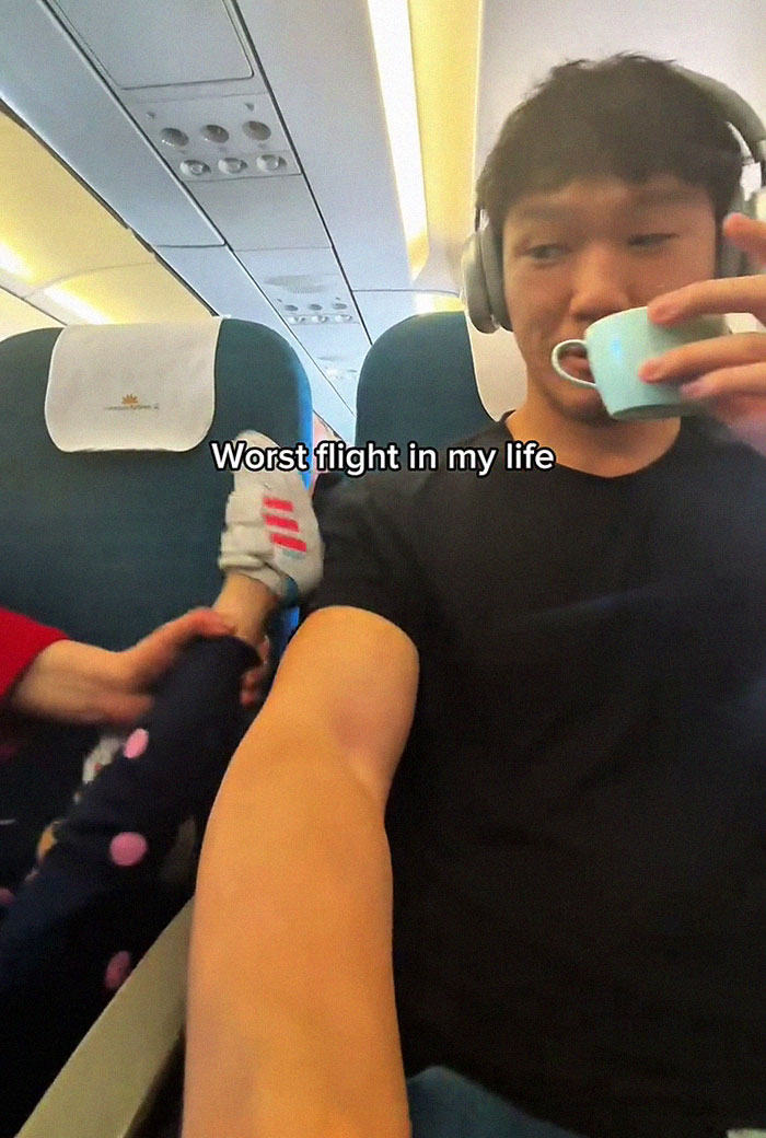 Frequent traveler experiences worst flight as a child kicks him on an airplane while he drinks from a small cup.