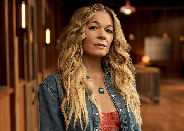 LeAnn Rimes with long blonde hair in a denim jacket speaking out about plastic surgery rumors weeks after teeth incident.