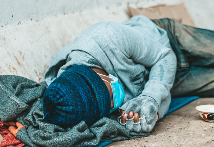 Person wearing a blue beanie and mask lying on the ground, evoking creepy and terrifying urban explorer moments.