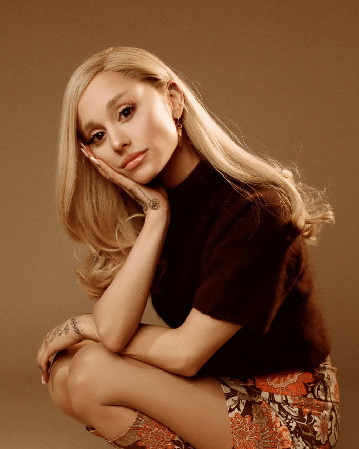 Ariana Grande posing with hand on face, showing fans' interest in specific type of plastic surgery before-and-after shots.