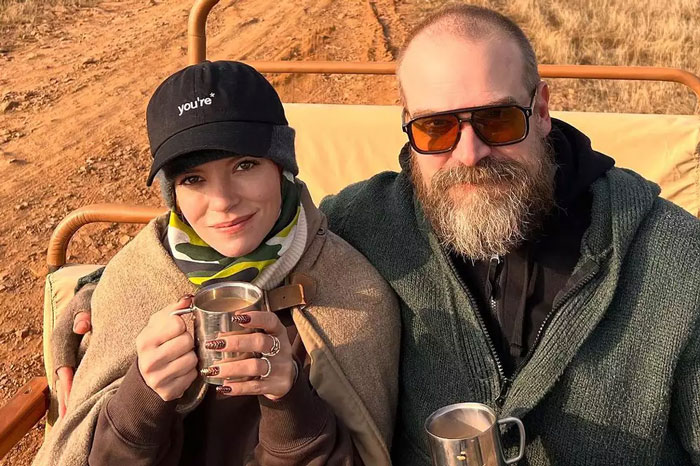 Lily Allen and a bearded man sitting outdoors holding metal cups, Lily Allen&rsquo;s CFDA fashion look sparking debate online.