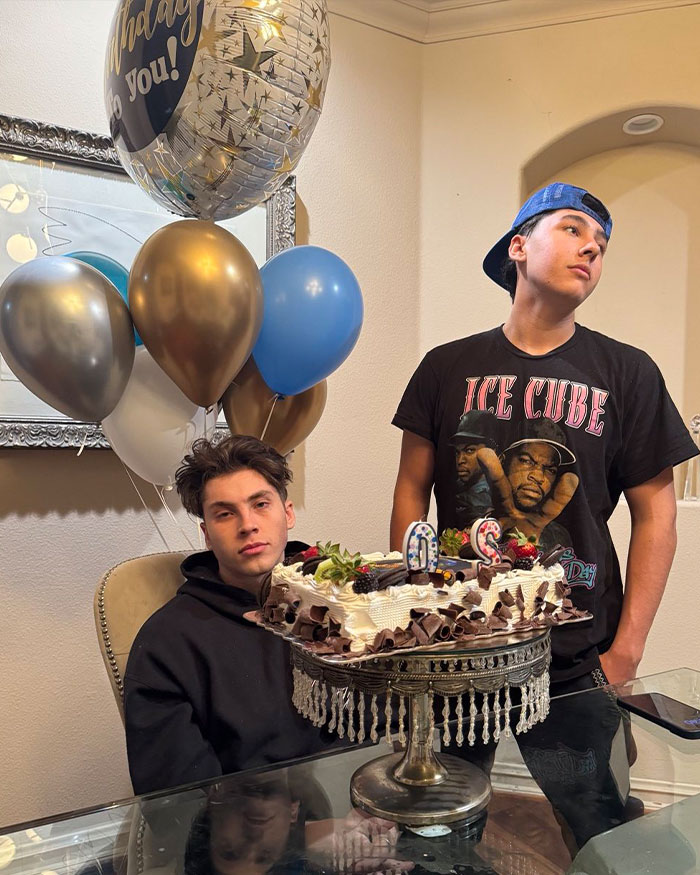 Two young men celebrating with a birthday cake and balloons, unrelated to fake plastic surgeon or silicone injections news.