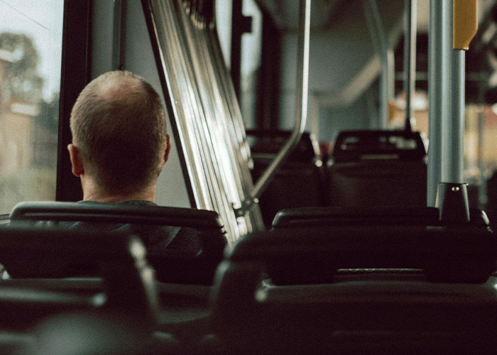 A man sitting alone on a bus, creating a quiet and eerie atmosphere for bizarre events that creep people out.