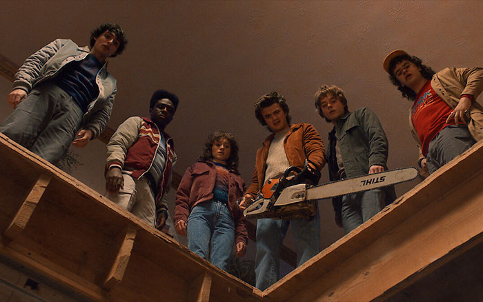 Stranger Things cast standing around a hole indoors, one holding a chainsaw, highlighting challenges of child actors becoming adult actors. Stranger Things cast standing around a hole indoors, one holding a chainsaw, highlighting challenges of child actors becoming adult actors.