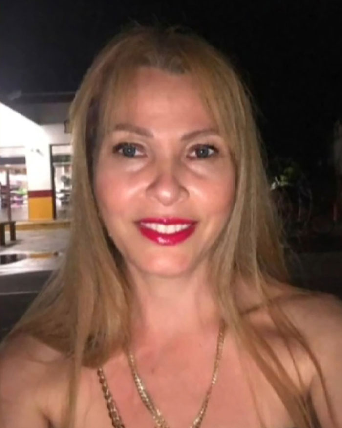 Woman smiling outdoors at night, highlighting risks faced by women who had a BBL in their quest for perfect curves.