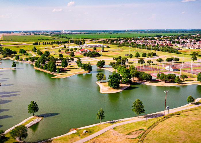 Aerial view of a suburban area with a park and lake in one of the worst cities worldwide to visit.