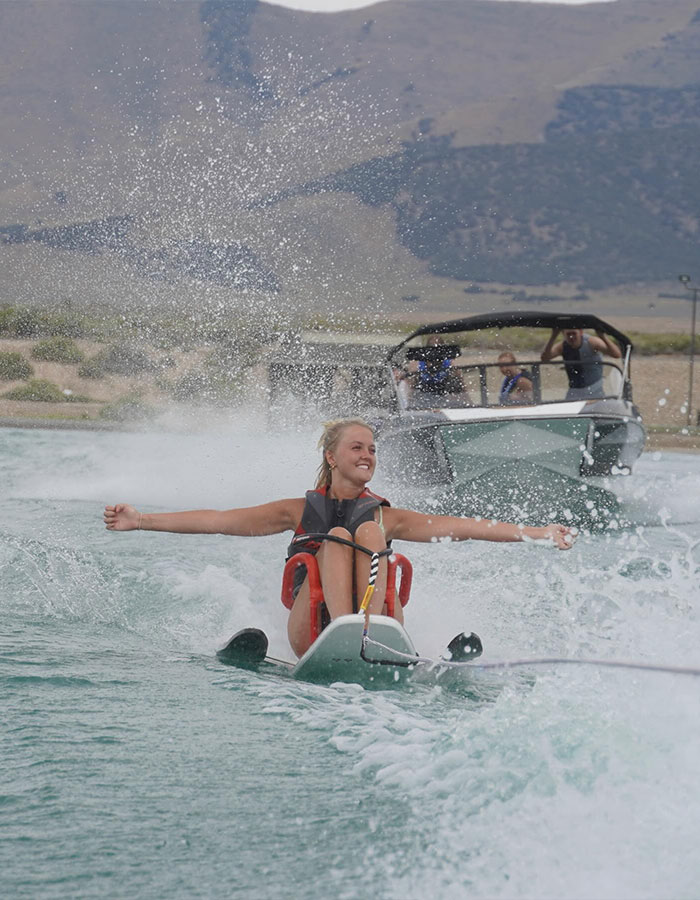 Girl waterskiing with a smile, enjoying a fun adventure before a basic mistake caused paralysis at 16.