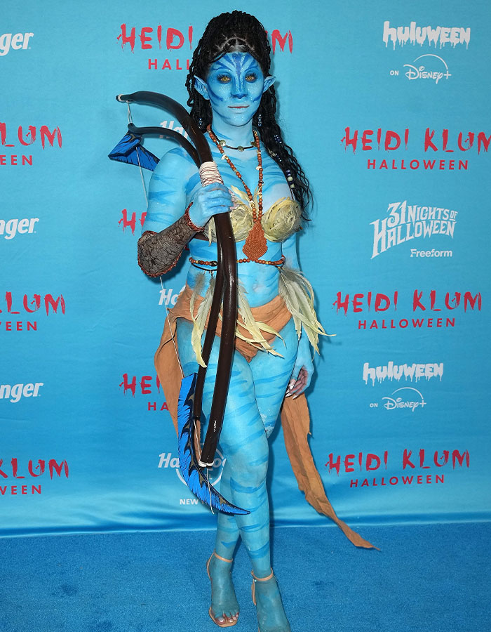 Disfraz de celebridad azul con arco en evento de Halloween de Heidi Klum, destacando entre los disfraces más impactantes.